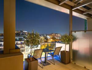 a patio with a table and chairs on a balcony at Ilisia Hotel Athens in Athens