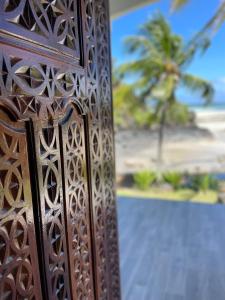 a wooden door with a palm tree in the background at Salama Eco-Lodge and Hostel in Mitsamiouli