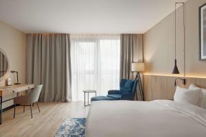 a hotel room with a bed and a chair and a desk at Lake Hill Mazury, a member of Radisson Individuals in Ostróda