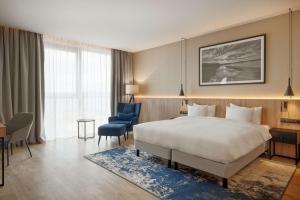 a hotel room with a bed and a blue chair at Lake Hill Mazury, a member of Radisson Individuals in Ostróda +109 photos
