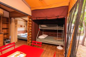 Camping Onlycamp Les Tuillères في Vercheny: غرفة نوم بسريرين في خيمة