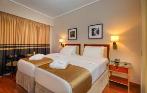 a bedroom with a large bed with two towels on it at Ilisia Hotel Athens in Athens