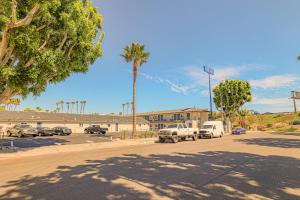 a parking lot with parked cars and palm trees at Motel 6 Tustin, CA Orange County in Tustin