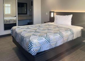 タスティンにあるMotel 6 Tustin, CA Orange Countyの大型ベッド1台が備わるホテルルームのベッド1台分です。