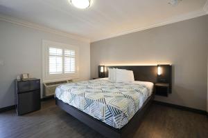 Un dormitorio con una cama grande y una ventana en Motel 6 Tustin, CA Orange County en Tustin