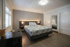 a bedroom with a bed and a desk and a mirror at Motel 6, Tustin, Orange County-CA in Tustin