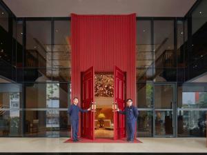 two men are standing in front of a red door at Grand Mercure Hanoi in Hanoi
