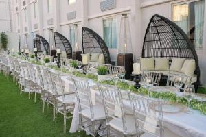 a long white table with white chairs and candles at Ramada by Wyndham DFW Airport in Irving