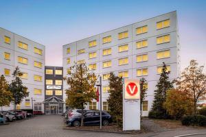 a white building with a sign in front of it at Vienna House Easy by Wyndham Neckarsulm in Neckarsulm