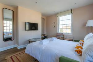a bedroom with a white bed and a tv at Palm Heights - top floor luxury flat in Margate