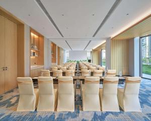 a conference room with a long table and chairs at Hyatt Place Yantai Development Zone in Yantai
