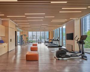 a gym with a row of treadmills and exercise equipment at Hyatt Place Yantai Development Zone in Yantai