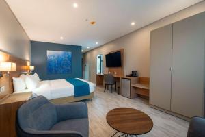 um quarto de hotel com uma cama e uma secretária em Tryp by Wyndham Asuncion em Assunção