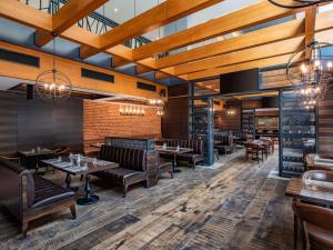 a restaurant with wooden ceilings and tables and chairs at Tbilisi Saburtalo Hotel by Mercure in Tbilisi City
