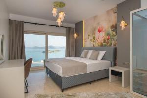 een slaapkamer met een groot bed en een groot raam bij BEACH FRONT SUPER VİLLA Boss 2 in Bodrum City