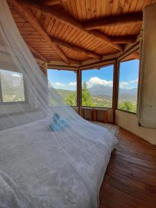 1 dormitorio con 1 cama en una habitación con ventanas en Swiss Eco Lodge La Linda Loma - Olmué, en Olmué