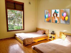 2 camas en una habitación con 2 ventanas y globos en vita homestay Măng Đen, en Kon Von Kla