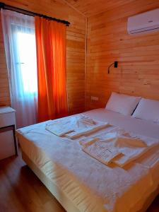 1 cama en un dormitorio de madera con ventana en Chirali Eco Villa en Kemer