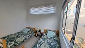 a small room with two beds and a table at Suikerbos Huisje in Mossel Bay