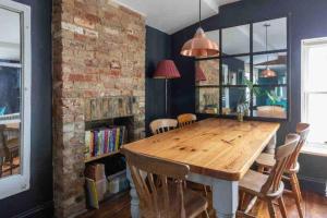 a dining room with a wooden table and a brick wall at SEA BREEZE APARTMENT in Margate