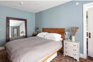 a bedroom with a large bed and a mirror at SEA BREEZE APARTMENT in Margate