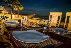 una mesa con un plato de comida en la playa en PEARL STAR BEACH RESORT, en Alankuda