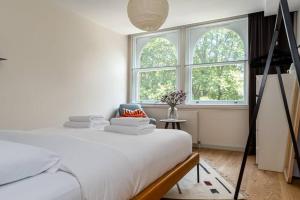 um quarto branco com uma cama e 2 janelas em 2 bedroom apartment in London Bridge em Londres