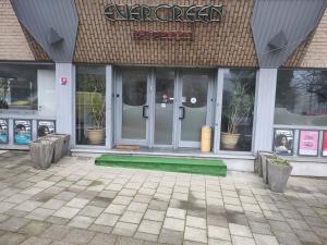 un devant de magasin avec un tapis vert devant les portes dans l'établissement Hotel Evergreen, à Bruxelles