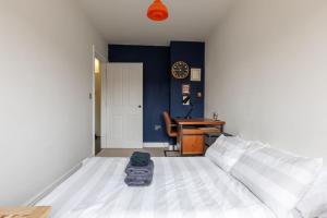 a bedroom with a bed and a desk with a clock at SEA HEIGHTS MARGATE in Margate