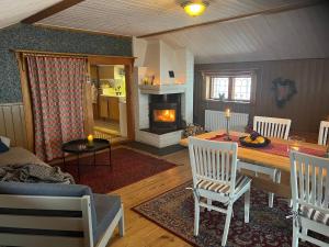 a living room with a table and a fireplace at Åsengården Boende & Gästgiveri in Asen