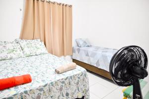 Habitación con 2 camas y ventilador. en Hostel mineiros, en Aracaju