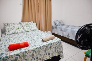Un dormitorio con una cama con un objeto rojo. en Hostel mineiros, en Aracaju