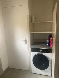een kleine keuken met een wasmachine en een deur bij Le coetquentellien in Pleudihen-sur-Rance
