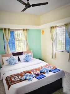 a bed in a room with blue walls and windows at Venus Villa in Panchgani