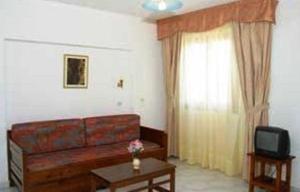 a living room with a couch and a television at Odyssey Hotel Apartments in Karpathos