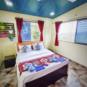 a bedroom with a large bed with red curtains at Venus Villa in Panchgani