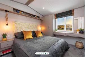 1 dormitorio con 1 cama grande y 2 ventanas en Two bedroom Holiday home, en Newquay