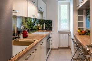 a kitchen with white cabinets and a sink at Sunny apartment in Trnava in Trnava