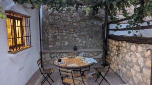 a table and chairs in front of a stone wall at Molino Viejo de Salar in Salar