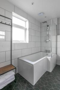 uma casa de banho branca com uma banheira e uma janela em Stones Throw em Margate