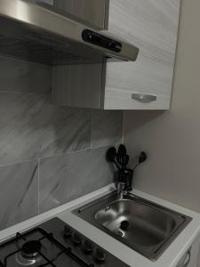 a kitchen counter with a sink and a stove at B&B Dei Vicari in Frattamaggiore