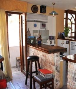 a kitchen with a counter and a bar with stools at Odyssey Hotel Apartments in Karpathos