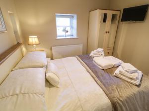 a bedroom with a bed with towels on it at Lough Island Reavy Cottage in Newry