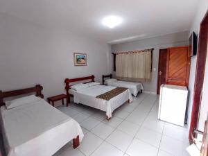 - une chambre avec 2 lits et une télévision dans l'établissement Pousada Cheiro de Mar, à Nova Viçosa