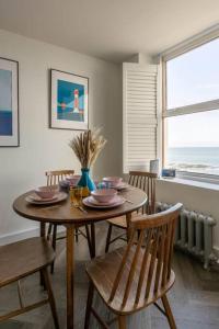a dining room with a table and chairs and a window at Stunning Sea Views @ The Lido Lounge in Margate