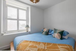 a bedroom with a bed with blue sheets and a window at Stunning Sea Views @ The Lido Lounge in Margate