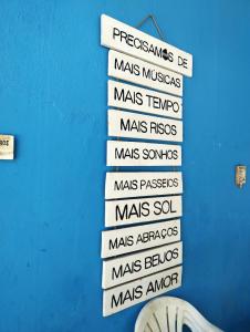 a group of street signs on a blue wall at Pousada Maravilha Geribá in Búzios
