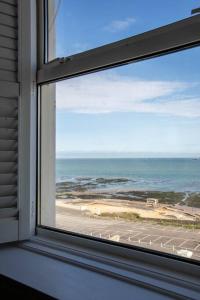 a window with a view of a beach and the ocean at Stunning Sea Views @ The Lido Lounge in Margate