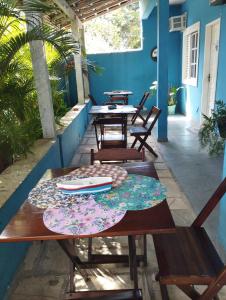 eine Terrasse mit Tischen und Stühlen an einer blauen Wand in der Unterkunft Pousada Maravilha Geribá in Búzios