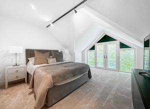 een witte slaapkamer met een bed en een aantal ramen bij 2 Bedroomed apt by Sefton Park and Spire Hospital in Liverpool